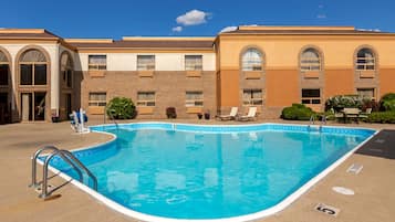 Una piscina al aire libre de temporada, sillones reclinables de piscina