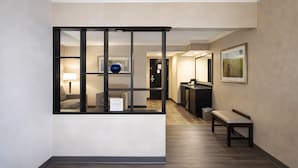 A hallway with a reception desk, a bench, and framed artwork on the walls. - Best Western Davison Inn (Davison)