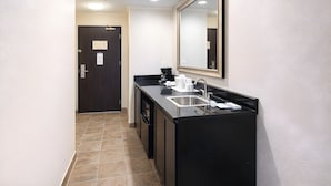 A modern bathroom with a black sink, a mirror, and a dark door. - Best Western Davison Inn (Davison)