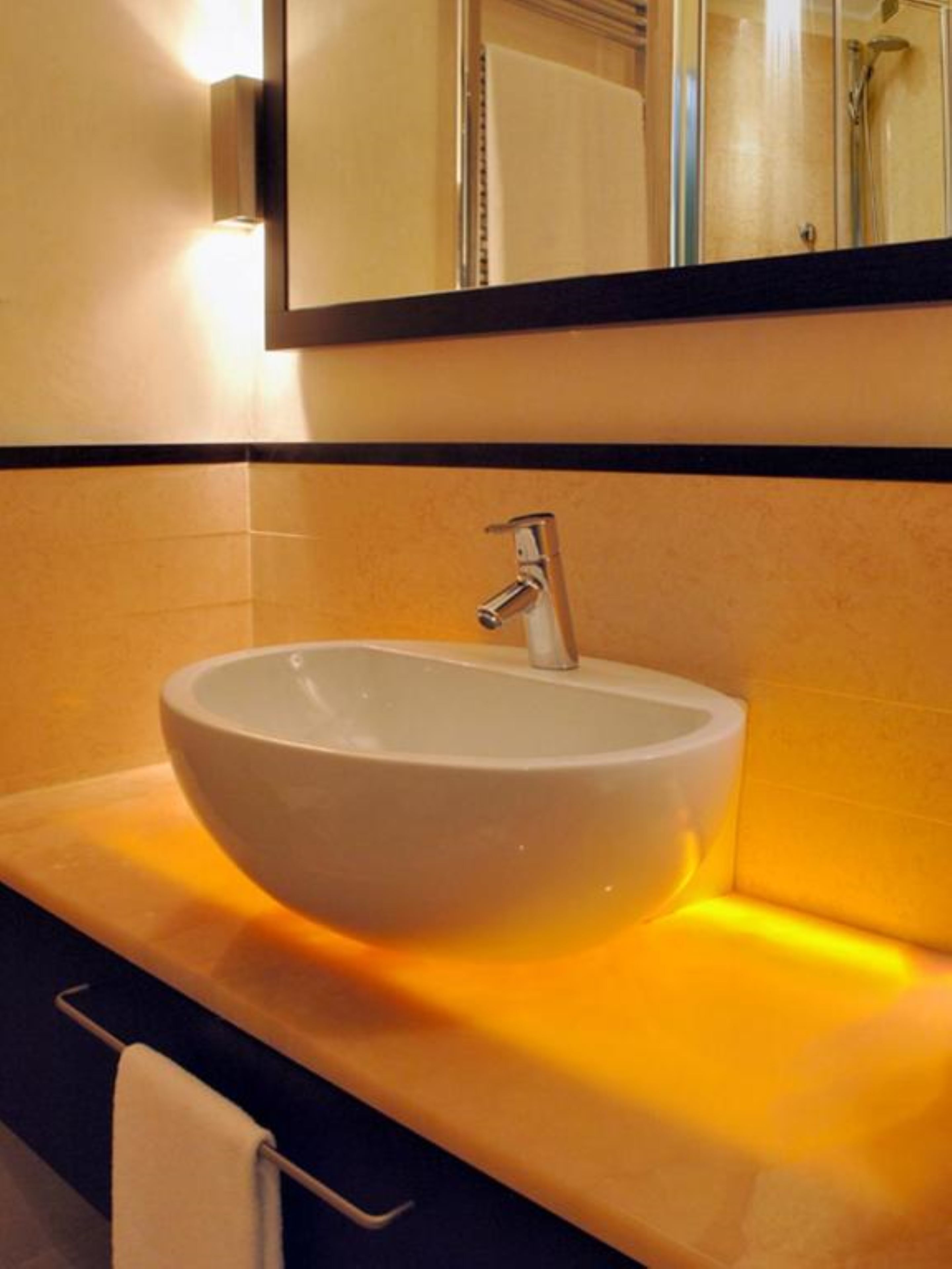 A bathroom with a white sink, a mirror above it, and a towel rack.