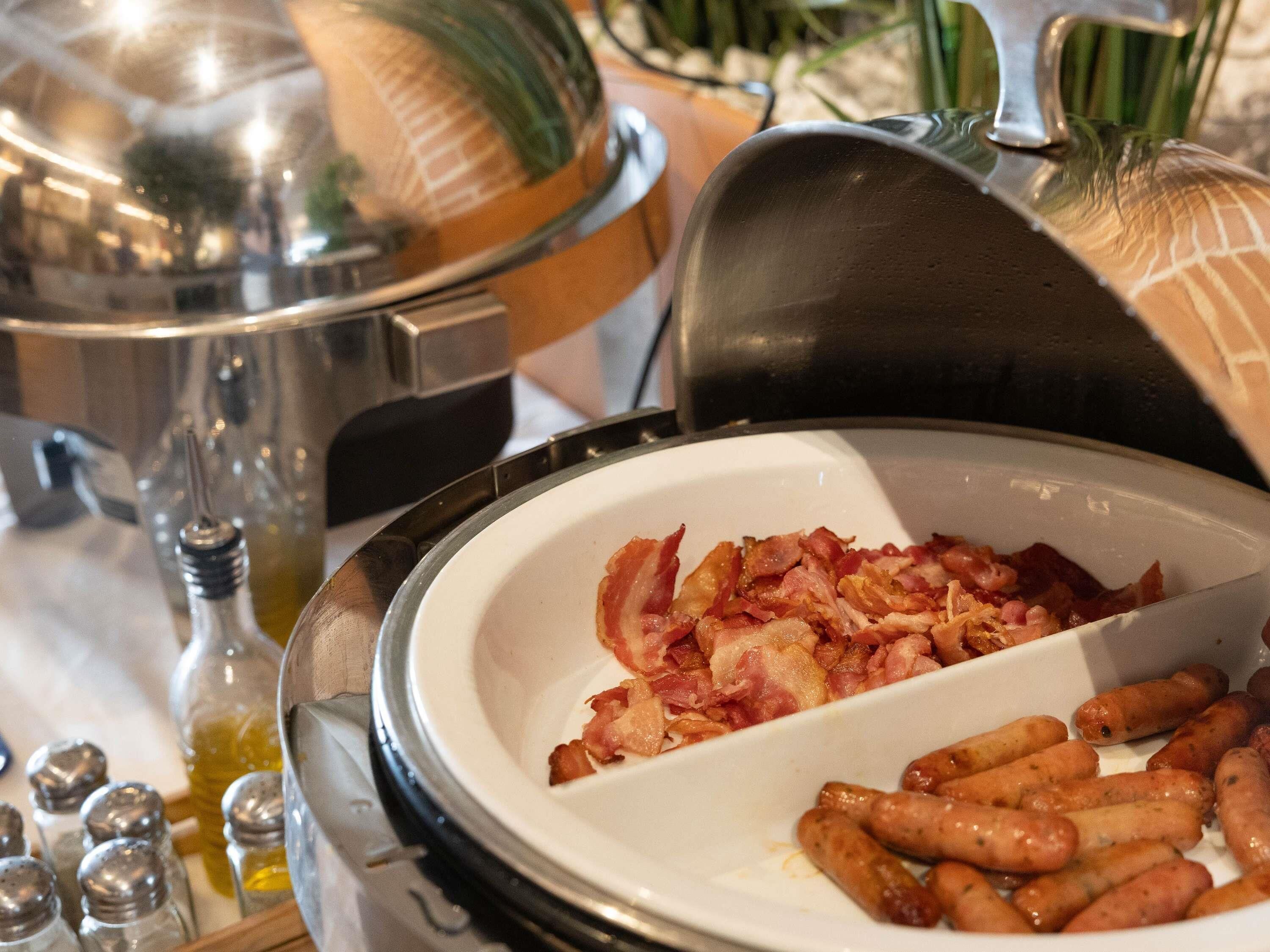Een ontbijtbuffet met spek en worstjes.
