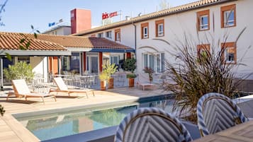 Seasonal outdoor pool, open 10:00 AM to 10:00 PM, pool umbrellas