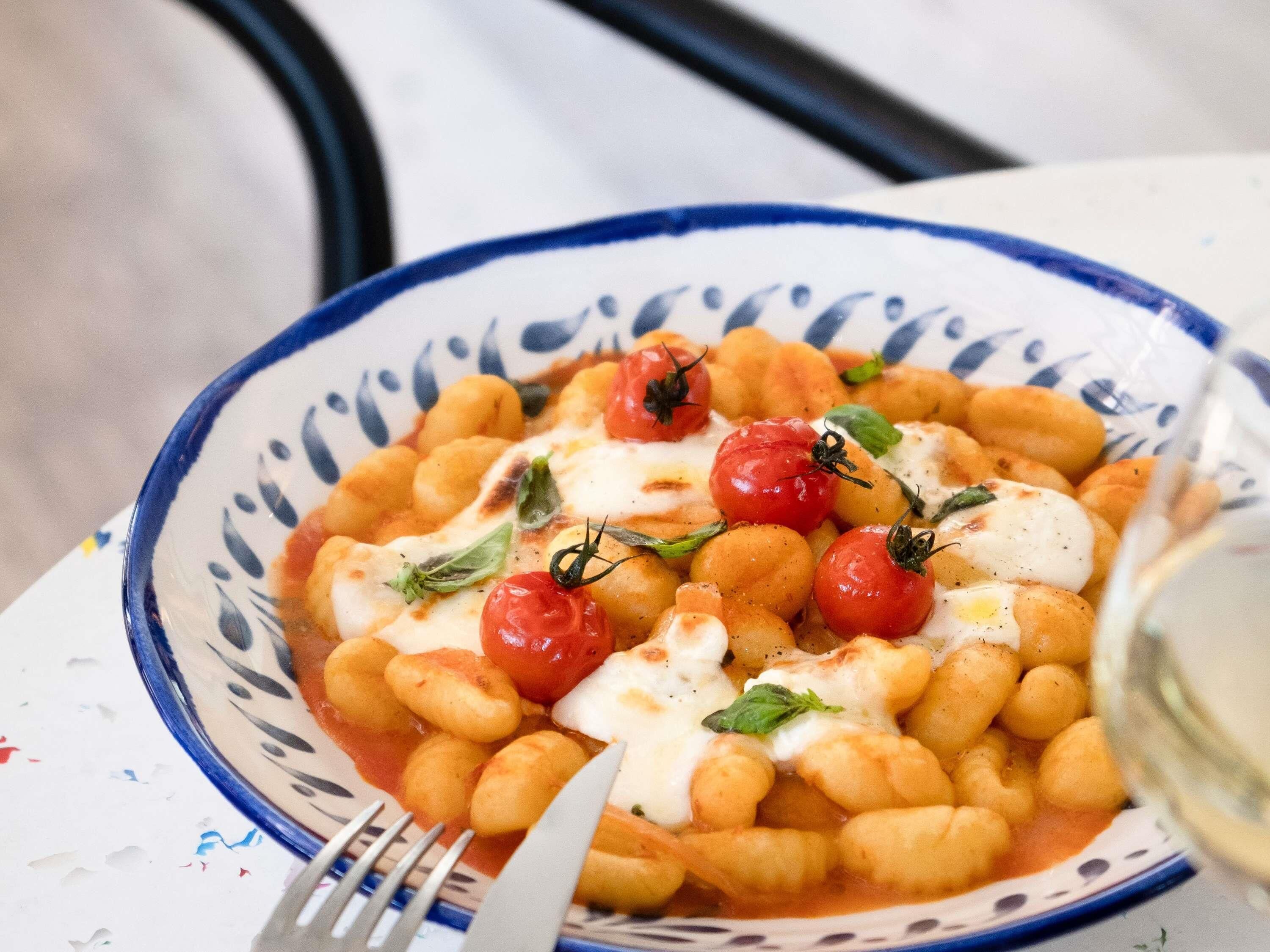 Un tazón de pasta con tomates cereza y albahaca.