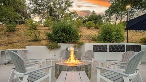 An outdoor seating area with Adirondack chairs and a central fire pit. - Best Western Plus Novato Oaks Inn (Novato)