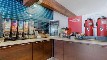 A kitchen with a coffee station, including a coffee machine and containers of coffee beans.
