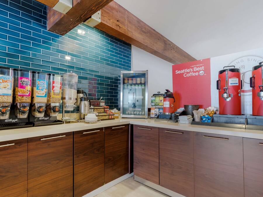 A kitchen with a coffee station, including a coffee machine and containers of coffee beans.