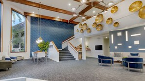 A spacious lobby with a staircase, modern furniture, and decorative wall art. - Best Western Plus Novato Oaks Inn (Novato)
