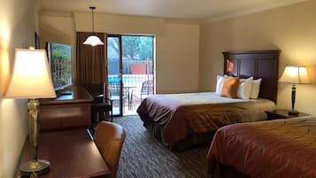 Una camera d'albergo con un letto, una scrivania, una sedia, una lampada e vista sull'esterno.