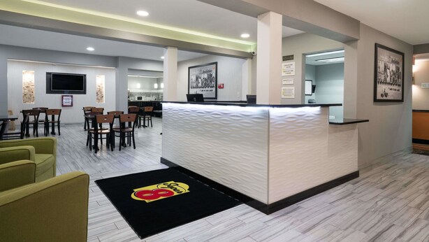 A hotel lobby with a reception desk, seating area, and a bar. - Super 8 by Wyndham Rochester Mayo Clinic Area (Rochester)