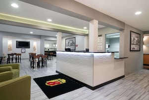 Vestíbulo de hotel con mostrador de recepción, zona de estar y bar.