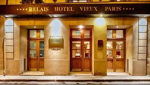The exterior of the Relais Hotel Vieux Paris, featuring a classic facade with large wooden doors and a signboard above the entrance.