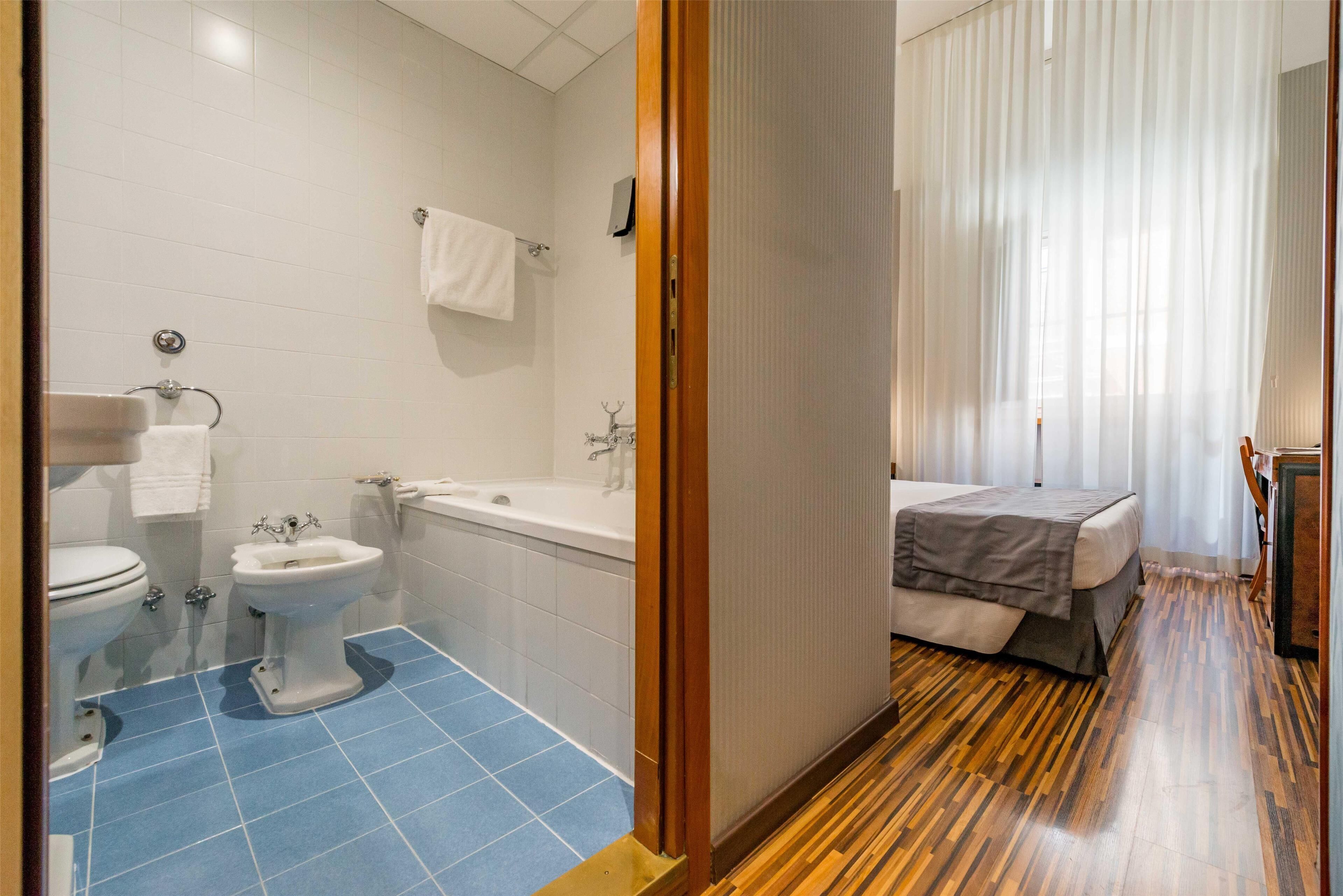 Une salle de bain d’hôtel équipée de toilettes, d’un lavabo et d’une baignoire.