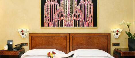 A hotel room with a large bed, a tray with food and flowers, a wine bucket, and a painting on the wall.