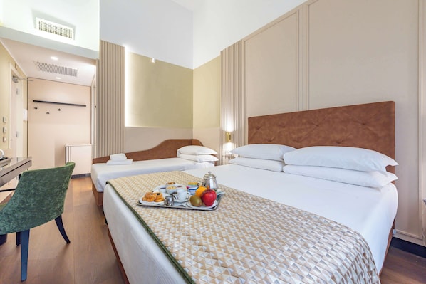 A hotel room with a bed, a desk, a chair, and a tray of breakfast items. - Best Western Hotel Artdeco (Rome)