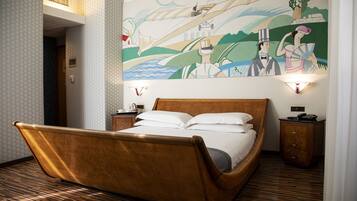 Una habitación con una cama de madera, un mural en la pared y una mesita de noche con una lámpara.