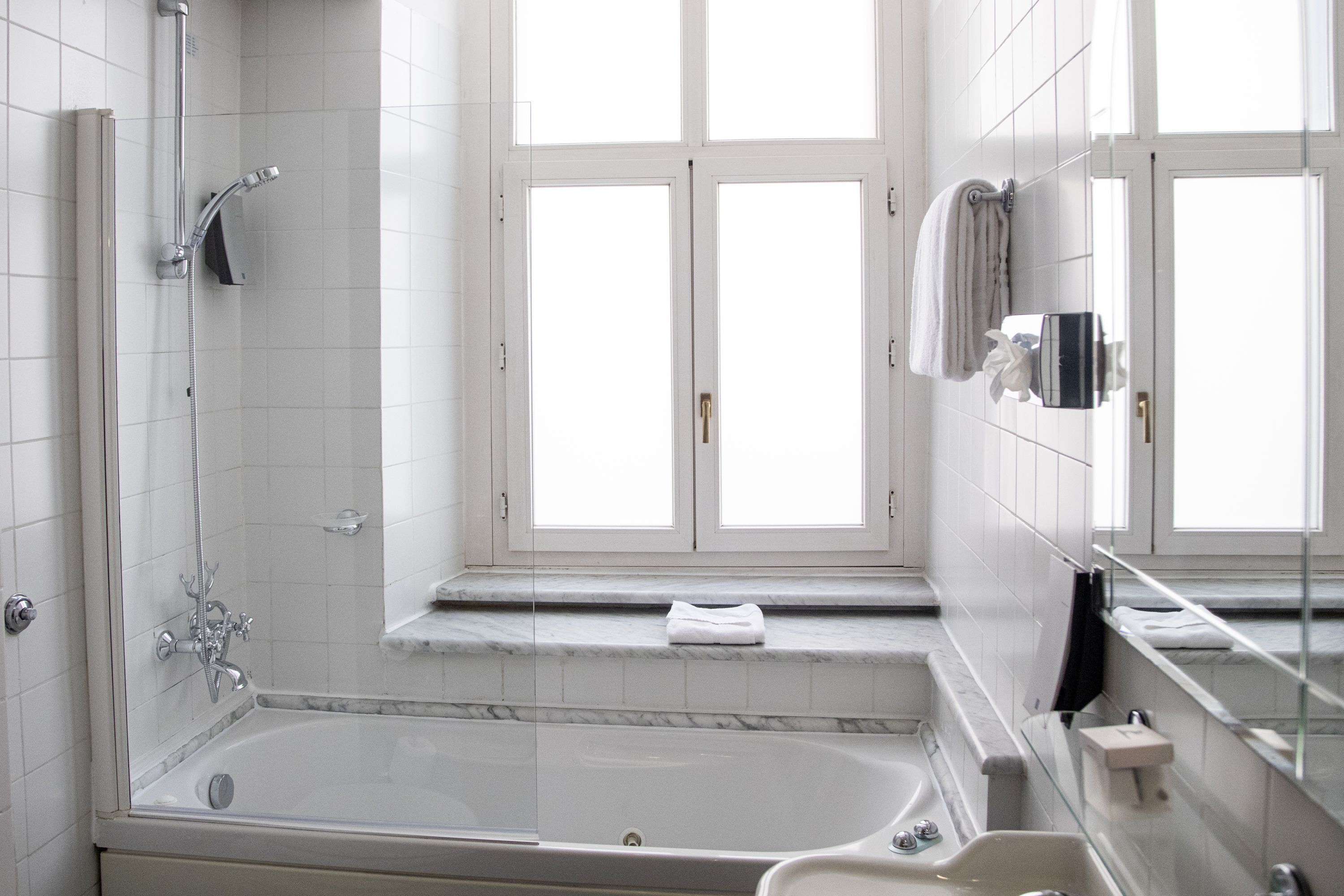 A modern bathroom with a bathtub, a shower, and a sink.