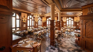 A spacious restaurant with wooden furniture, hexagonal patterned flooring, and large windows allowing natural light. - GAIA Hotel Basel - the sustainable hotel (Basel)