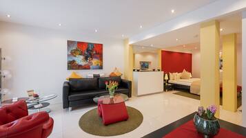 Exclusieve suite, 1 kingsize bed met slaapbank, kitchenette | Luxe beddengoed, een gratis minibar, een kluis op de kamer, een bureau