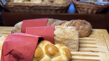 Variedad de panes y pasteles sobre una superficie de madera.