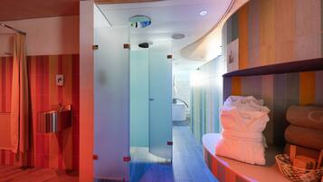 A modern bathroom with a glass shower enclosure, a sink, and a towel rack.