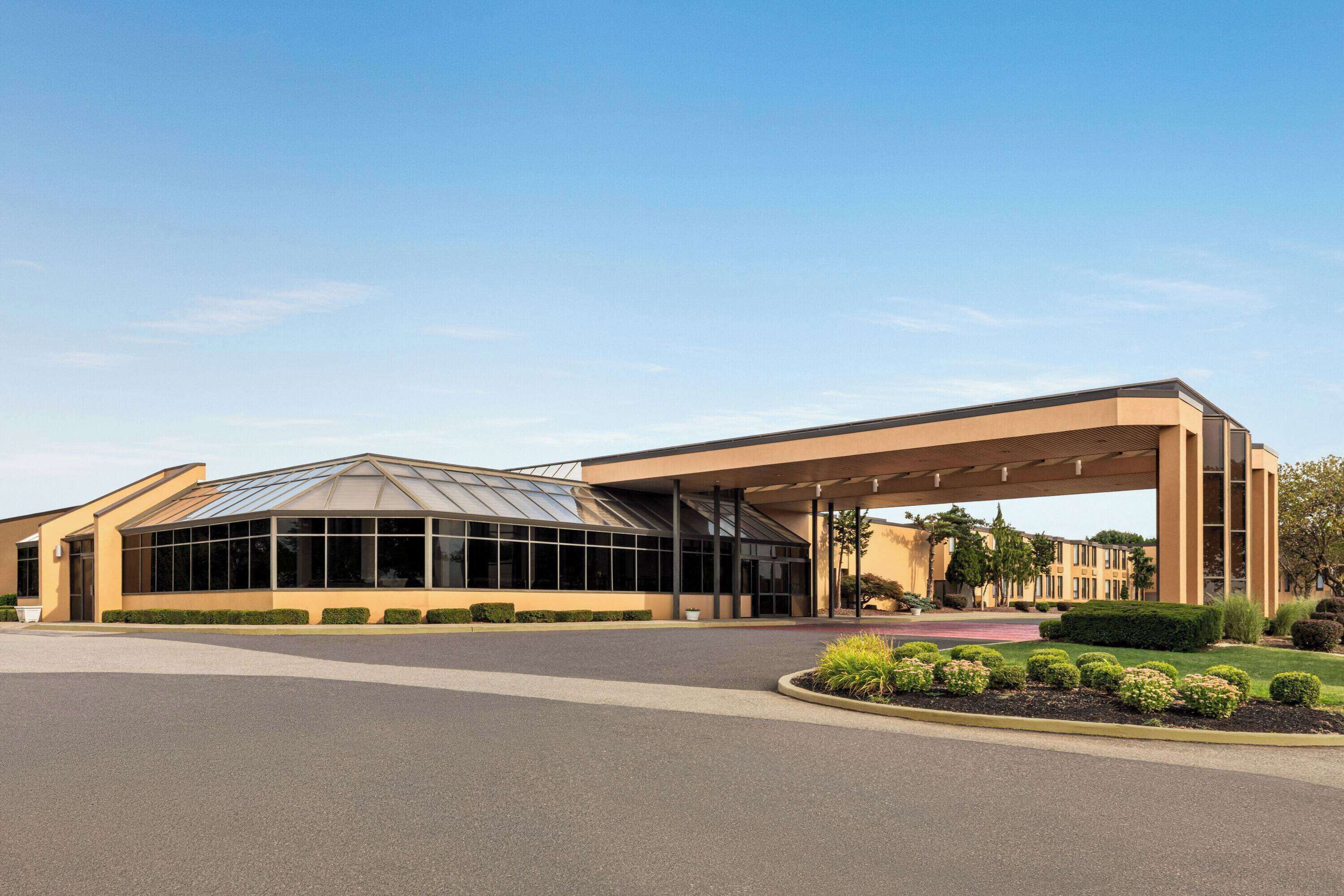A modern building with a large glass entrance and a covered walkway.