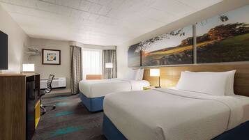 A hotel room with two beds, a desk, a chair, a TV, and a painting on the wall.