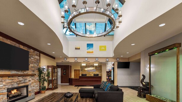 Un hall de hotel con chimenea, una recepción, un candelabro y un ventanal grande.