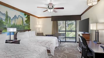 Quarto de hotel com duas camas, uma escrivaninha, uma cadeira, televisão e varanda com vista para árvores.