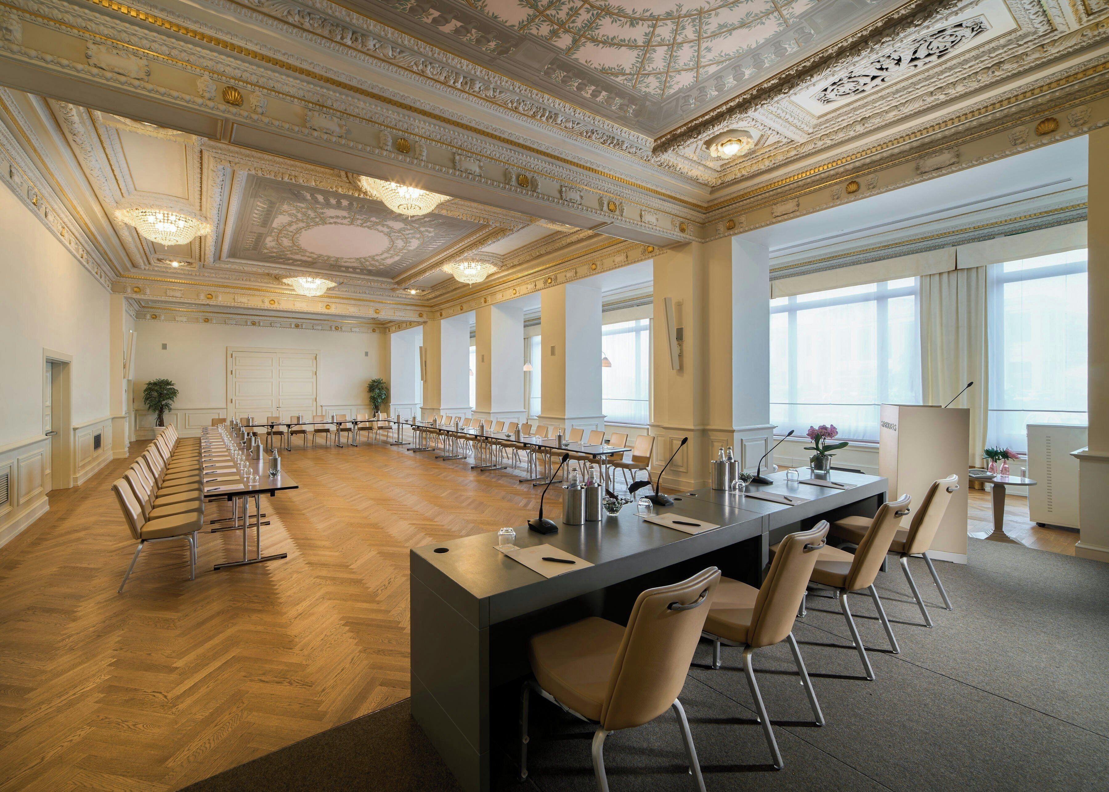 Une grande salle de conférence dotée d’une longue table, de chaises et d’un espace bar moderne.