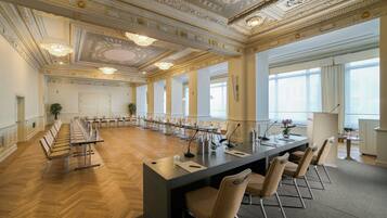 Une grande salle de conférence dotée d’une longue table, de chaises et d’un espace bar moderne.