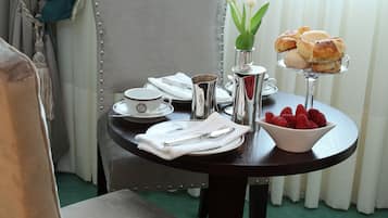 Una mesa con una silla y un bol de fresas.