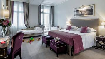 Una camera d'albergo con un letto grande, una scrivania, una sedia e un tavolino con dei giocattoli.
