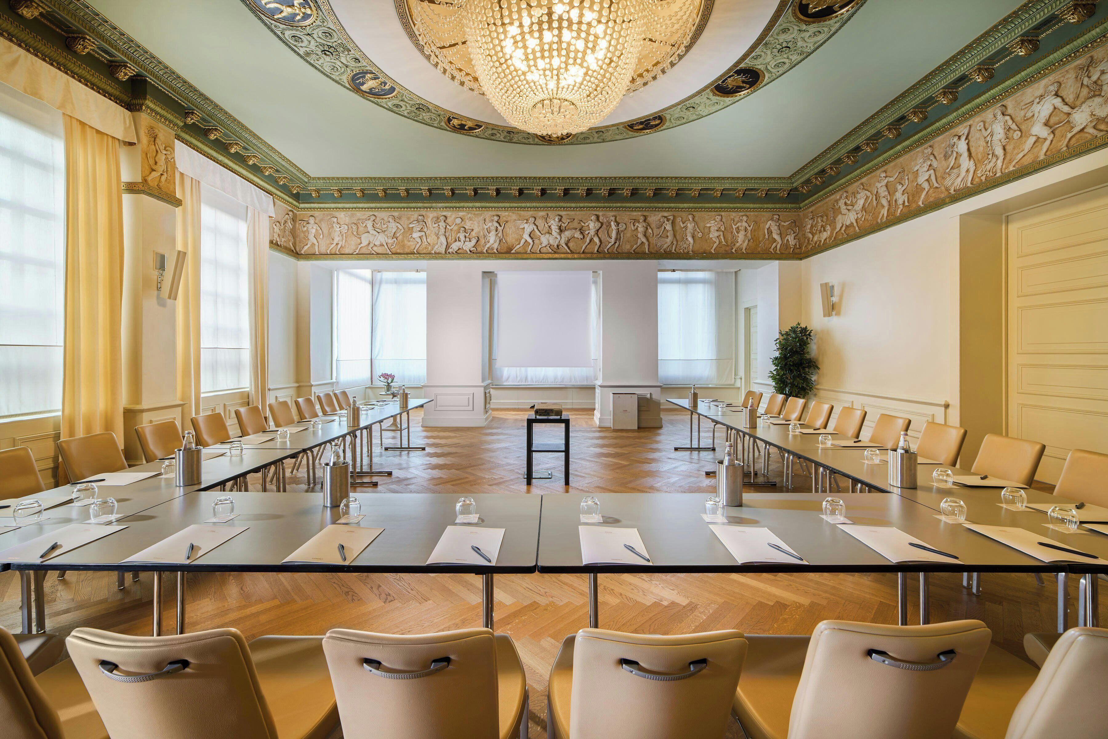 A conference room with a long table, chairs, and a chandelier.