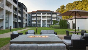 A courtyard with outdoor seating, a fire feature, and a building in the background. - Courtyard by Marriott Norwalk (Norwalk)