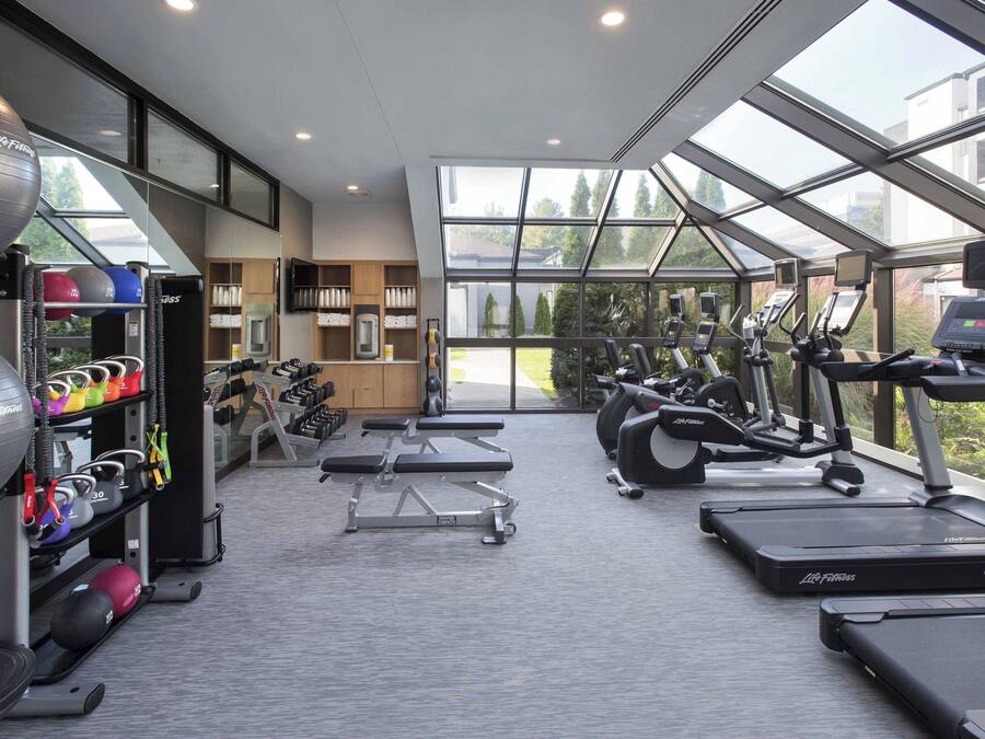 A gym with treadmills, elliptical machines, and free weights.