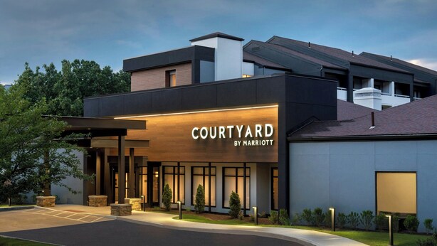 A modern Courtyard by Marriott hotel with a well-lit entrance, a covered outdoor area, and a landscaped garden. - Courtyard by Marriott Norwalk (Norwalk)