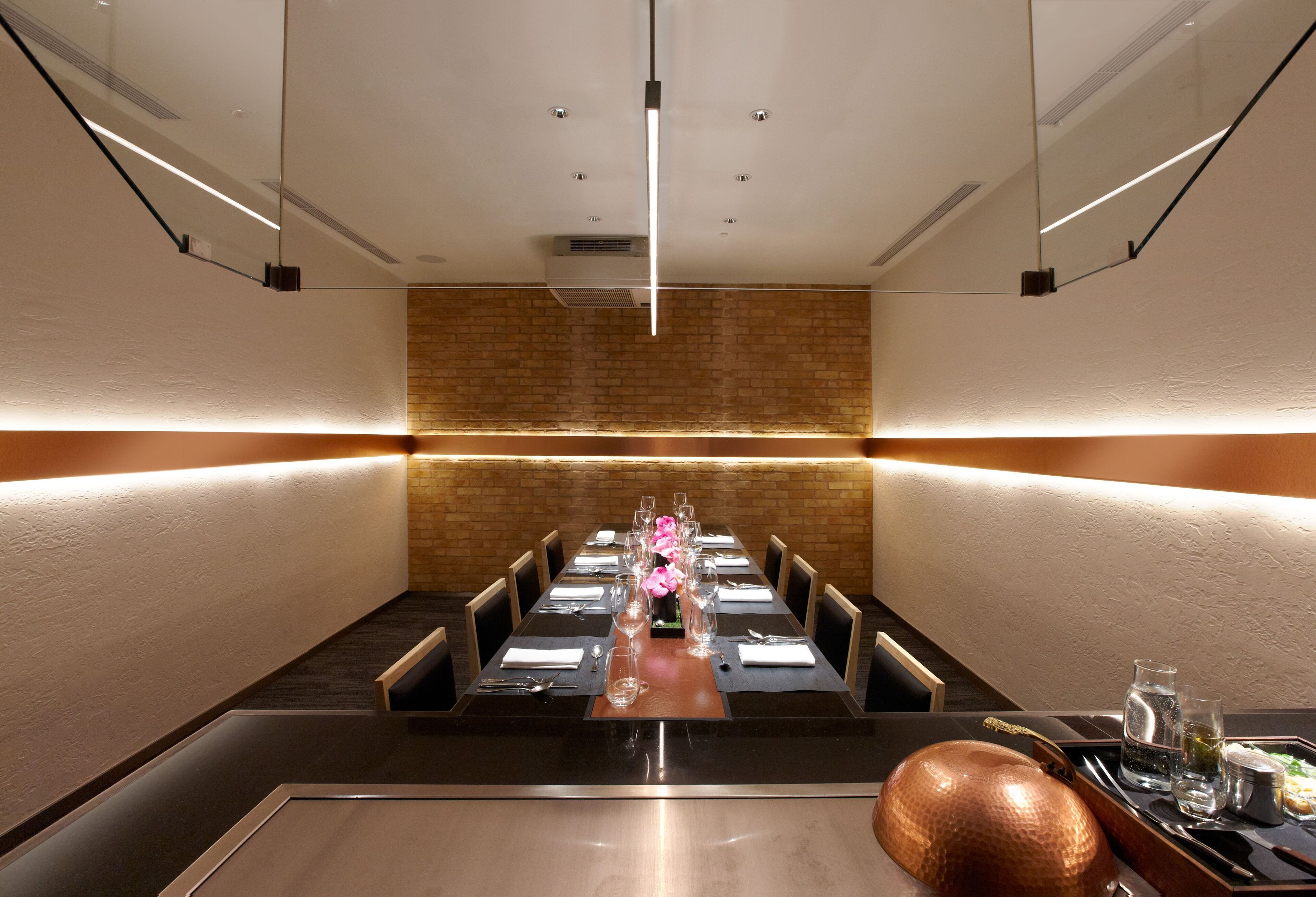 A conference room with a long table, chairs, and a central floral arrangement.