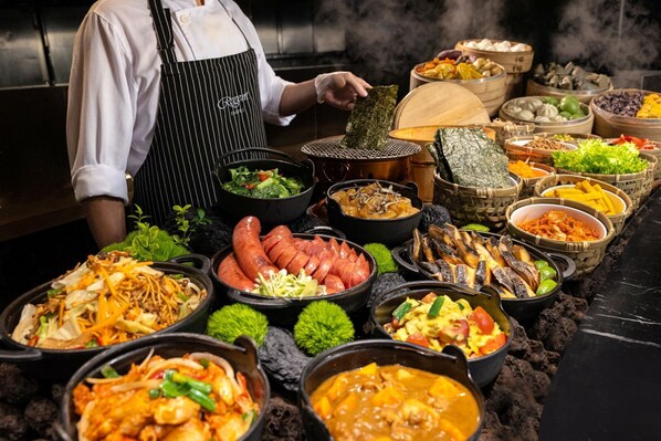 A buffet with various dishes, including seafood, vegetables, and meats.