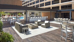 An outdoor patio area with seating and a pool. - Hilton Houston Plaza/Medical Center (Houston)