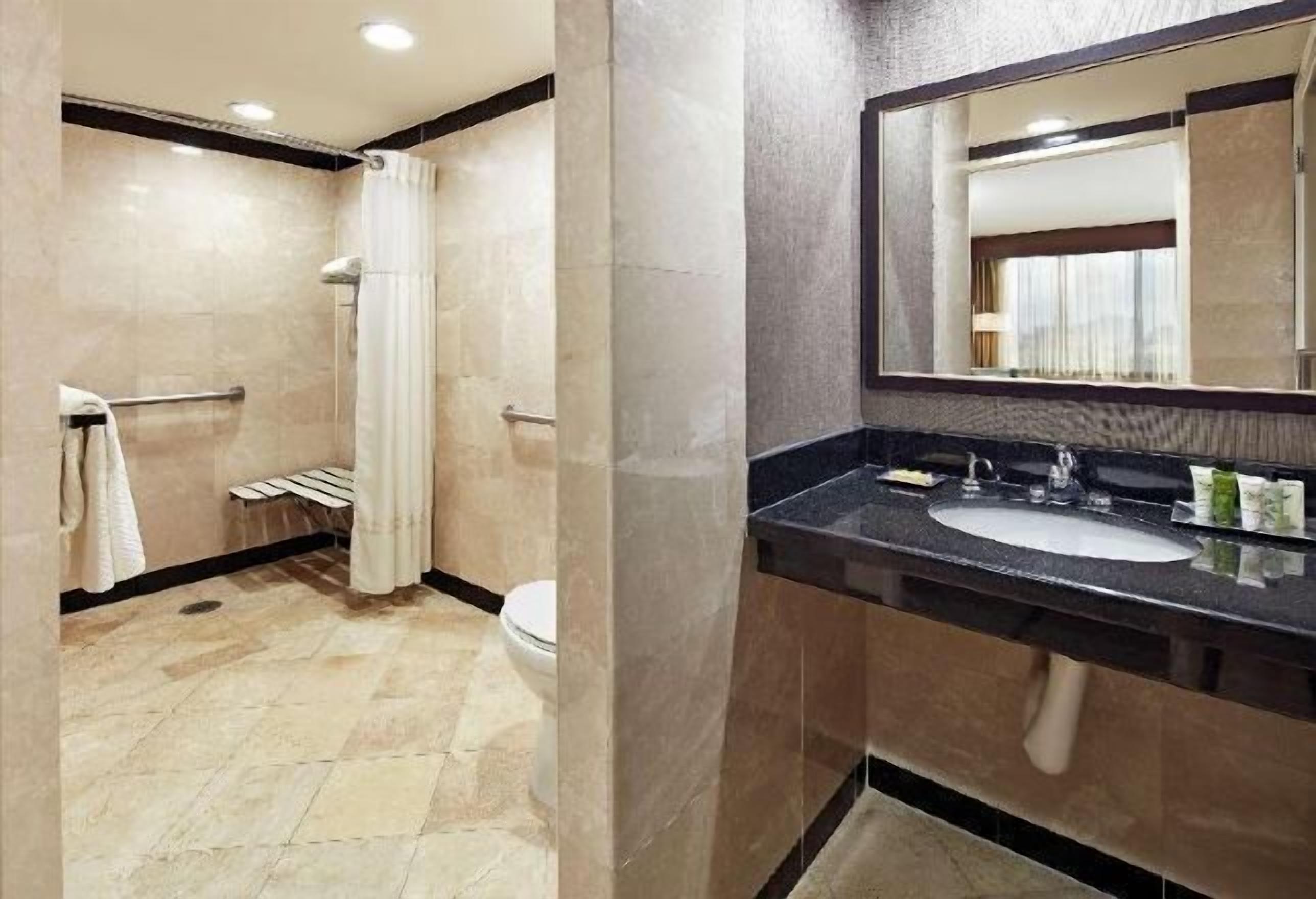 Badkamer | Een bad/douchecombinatie, gratis toiletartikelen, een haardroger