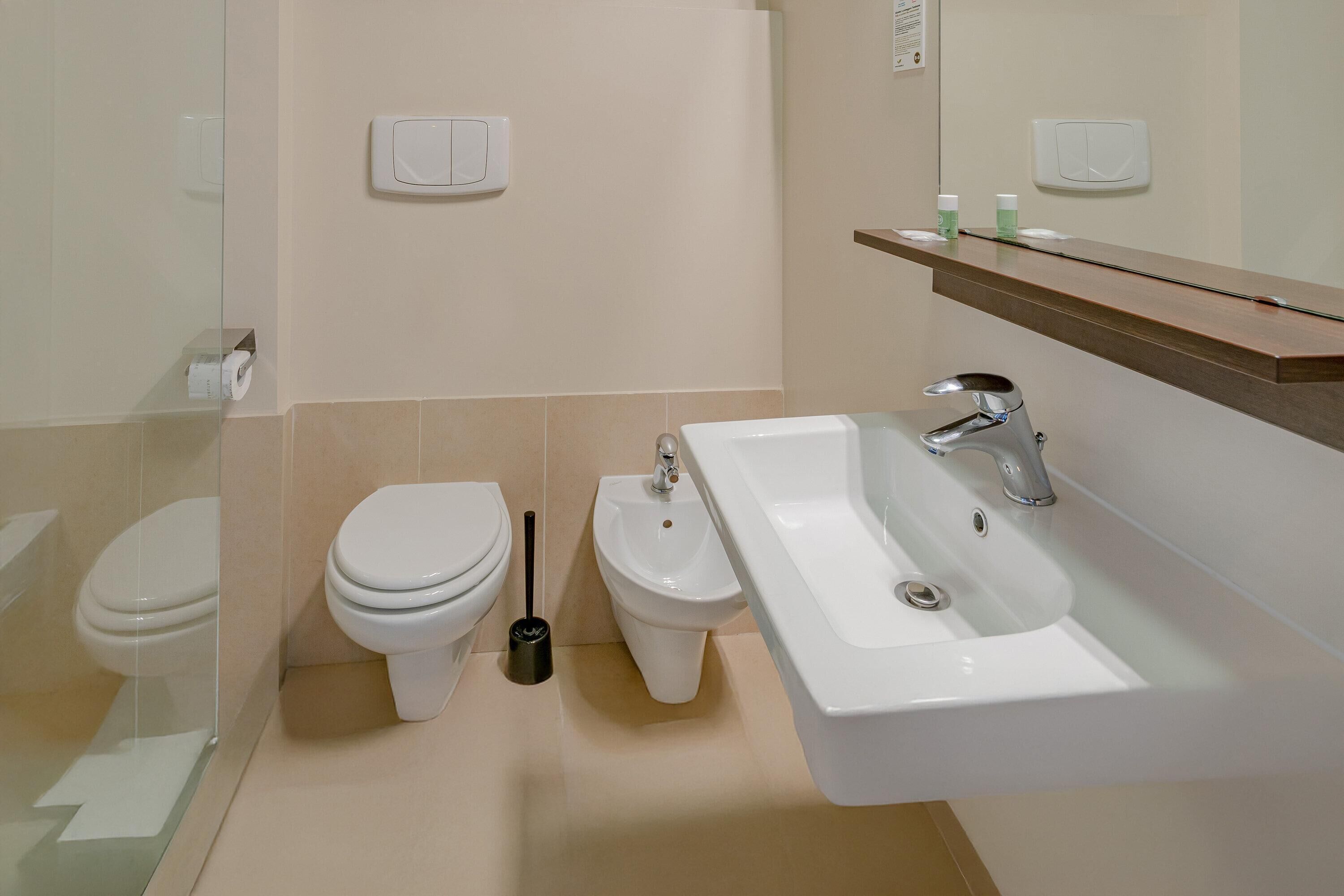 Un baño moderno con inodoro, bidé y lavamanos.