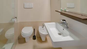 Un baño moderno con inodoro, bidé y lavamanos.