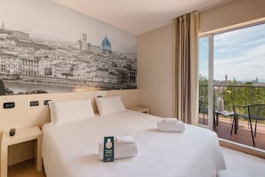 Une chambre d’hôtel avec un grand lit, une table de chevet, une horloge murale et une vue sur le paysage urbain depuis un balcon.