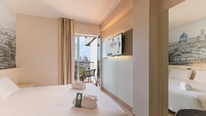 Habitación de hotel con dos camas, un balcón que ofrece vistas a un paisaje urbano, un televisor de pantalla plana montado en la pared y un cuadro enmarcado con una vista de la ciudad.
