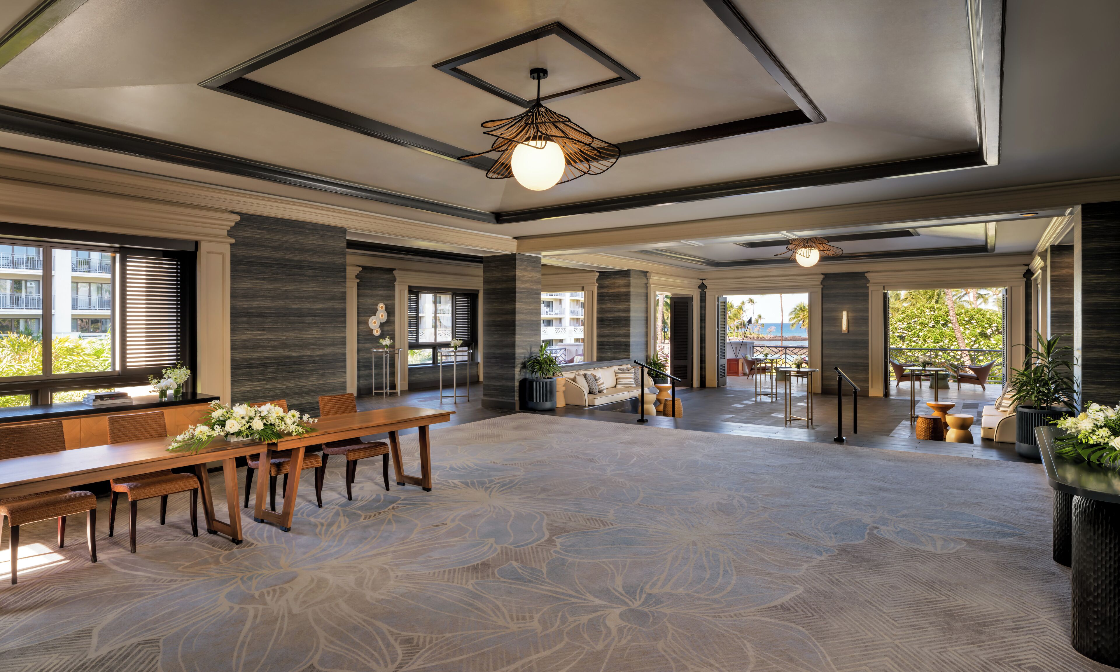 A spacious room with a dining area, a sofa, and a view of the outdoors.