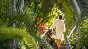A person ascending a staircase surrounded by lush greenery.