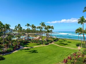 A resort with a pool, palm trees, and a view of the ocean. - Fairmont Orchid (Kohala Coast)