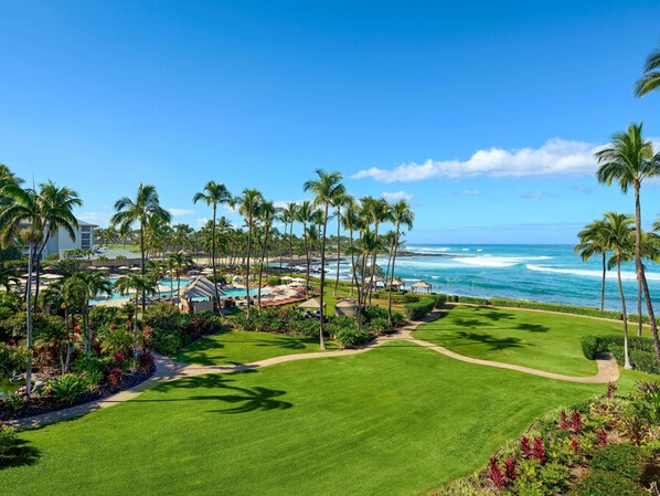 A resort with a pool, palm trees, and a view of the ocean. - Fairmont Orchid (Kohala Coast)