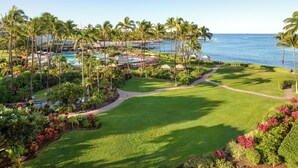 Ein Resort mit Pool, Palmen und Blick auf den Ozean.