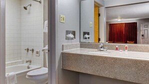 A bathroom with a bathtub, toilet, sink, and a mirror. - Econo Lodge Wichita Falls Downtown (Wichita Falls)